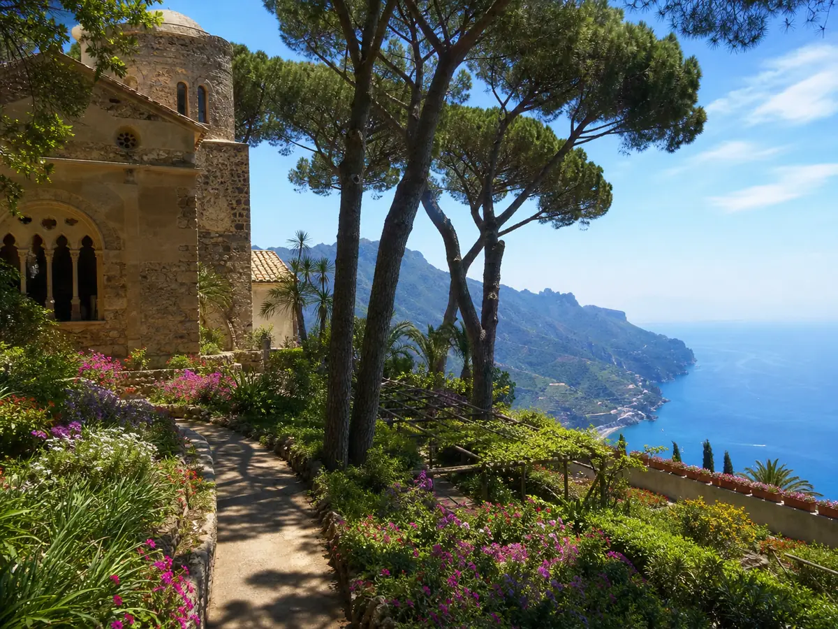 Blumenbeete und ein alter Steinturm in einem Garten in Ravello über dem Meer